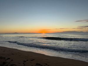 a sunset on a beach with the ocean at The Beach Loft by Xio in Humacao