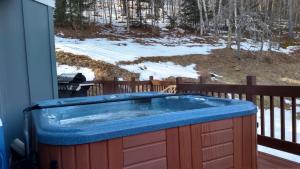 una bañera de hidromasaje en una terraza en la nieve en Val Roc Motel - Killington, en Killington