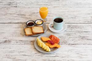 a table with a plate of food and a cup of coffee at Casa Astral Hotel Boutique and Apartments in Holbox Island