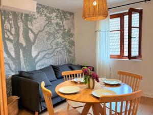a living room with a table and a couch at L'Adresse - Rempart Sud - Eguisheim avec garage privé in Eguisheim