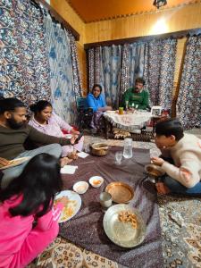 a group of people sitting around a table eating food at Minnat Home Stay in Srinagar +19 photos