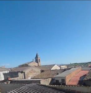 a view of the roofs of a town with a church at Casa Villa Zarcillo in Torreorgaz +2 photos