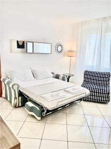 a white room with a bed and a chair at Tuanis in Naples