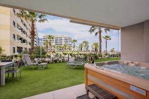 a hot tub in the middle of a yard with palm trees at Apartment Grape Panorama Mar Punta Prima in Punta Prima