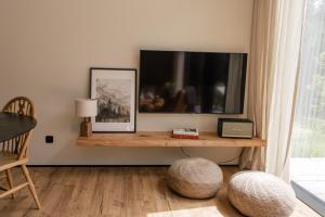 a living room with a television and a table at Chalets by Slow Tatry Boutique Resort&SPA in Zakopane