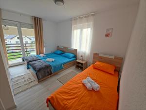 a bedroom with two twin beds and a balcony at Lone Star Apartments in Gusinje