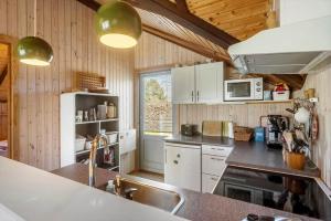 a kitchen with white cabinets and a counter top at M412-Stubbekobing-Birkehegnet-28 in Stubbekøbing +13 photos