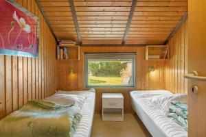 two beds in a small room with a window at M412-Stubbekobing-Birkehegnet-28 in Stubbekøbing