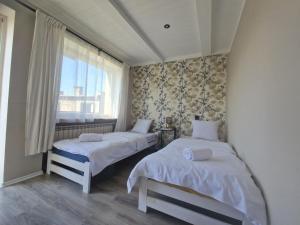 two beds in a room with a window at Promień 4 by Zen4Guest - Biskupin in Wrocław
