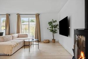 a living room with a couch and a fireplace at S745-Stroby-Garderhojen-35 in Strøby