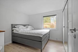 a bed in a room with a window at S745-Stroby-Garderhojen-35 in Strøby