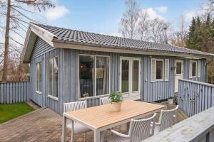 a tiny house with a table and chairs on a deck at S745-Stroby-Garderhojen-35 in Strøby