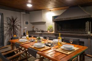 a wooden table in a kitchen with a fireplace at Cuervo Poolside Villa in Kalívia Thorikoú
