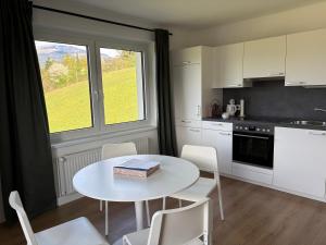 a kitchen with a table and chairs and a window at Ferienwohnung Amseltraum in Seeboden