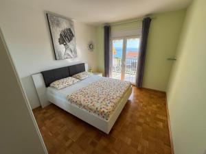 a bedroom with a bed and a large window at Apartman Marta in Podstrana