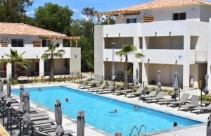 a hotel swimming pool with lounge chairs and a building at Magnifique T3 full équipé, 100m de la plage et piscine N60 in Linguizzetta