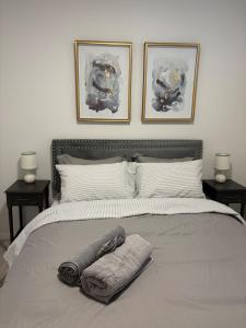 a bedroom with a bed with towels on it at Cobblebrook Executive Suites in Airdrie