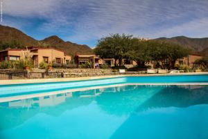 a blue swimming pool with mountains in the background at Miraluna Bodega Boutique in Cachí