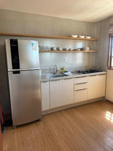 a kitchen with a stainless steel refrigerator and a sink at Flat com vista mar in Mucuri +17 photos