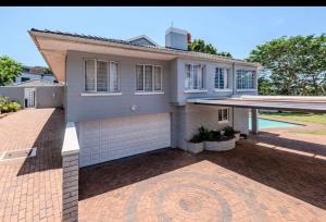 a house with a brick driveway in front of it at La Lucia Sleepover in Durban