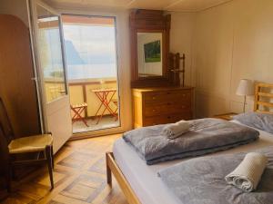 a bedroom with two twin beds and a balcony at BnB Villa Kapellmatt - Seezugang, Bio-Frühstück, SUP am Rigi in Vitznau