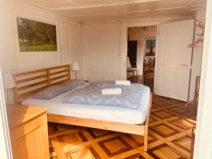a bed in a room with a wooden floor at BnB Villa Kapellmatt - Seezugang, Bio-Frühstück, SUP am Rigi in Vitznau