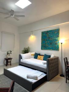 a living room with two beds and a ceiling fan at La Estadia in San Juan