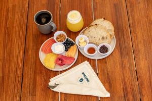 a table with two plates of breakfast foods and a cup of coffee at Beachfront Hotel Boutique DK in Holbox Island