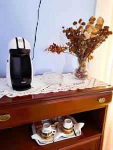 a table with a coffee maker and a vase of flowers at Hotel Imperial in Tazones