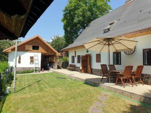 a patio with a table and chairs and an umbrella at Chalupa 58 in Štiavnické Bane