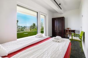 two beds in a room with a large window at Apartment La Lita Panoramic Sea View Parking Self Checkin in Šmarje