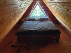 a bed in a small room with a window at Chalupa 58 in Štiavnické Bane