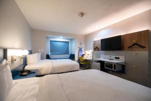 a hotel room with two beds and a desk at Microtel Inn & Suites by Wyndham Columbia in Columbia +13 photos