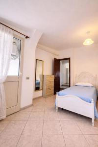 a bedroom with a bed and a window at Le Arcada - Appartamenti diffusi nel cuore del centro storico di Orosei in Orosei