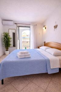 a bedroom with a large bed with towels on it at Le Arcada - Appartamenti diffusi nel cuore del centro storico di Orosei in Orosei