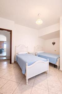 a bedroom with two beds in a room at Le Arcada - Appartamenti diffusi nel cuore del centro storico di Orosei in Orosei +149 photos