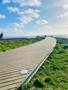 a boardwalk leading to the ocean on a beach at Casa Alto da Vela in Peniche +4 photos