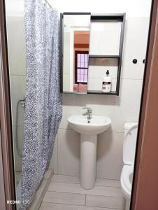 a bathroom with a sink and a shower curtain at Rise And Shine Rooms Korca in Korçë