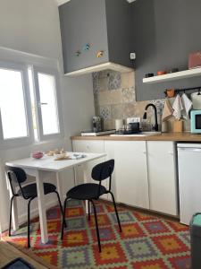 a kitchen with a white table and two chairs at Casa Alto da Vela in Peniche