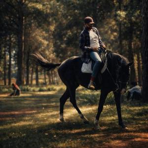 a man riding a horse in a field at Mahafaly Hotel & Resort in Antsirabe