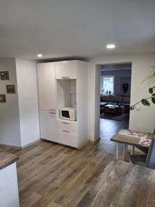 a living room with white cabinets and a microwave at Vybavený byt in Krásno +7 photos