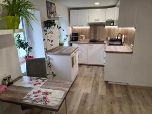 a kitchen with white cabinets and a wooden floor at Vybavený byt in Krásno