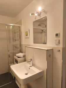 a white bathroom with a sink and a mirror at Am Schlosspark Potsdam in Potsdam +5 photos