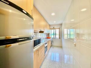 a large kitchen with white cabinets and a sink at Maria Borges Alojamento Local in Póvoa de Varzim