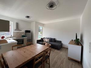 a kitchen and a living room with a wooden table at KutyaGazdi Apartman in Balatonfenyves