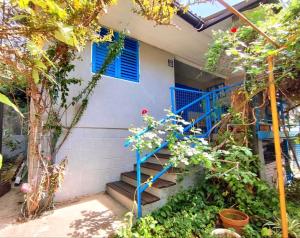 a house with blue stairs and flowers in front of it at Apartments Skipper bay Kumbor in Herceg-Novi
