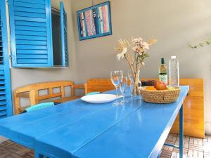 a blue table with a bowl of fruit and wine glasses at Apartments Skipper bay Kumbor in Herceg-Novi +5 photos