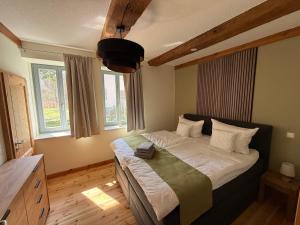 a bedroom with a bed and two windows at Forsthaus Boberow in Rheinsberg