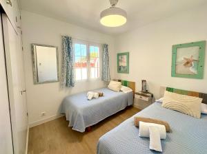 a bedroom with two beds and a window at Santa Brígida in Cala en Porter +23 photos