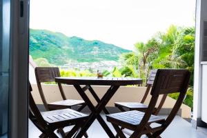 a table and chairs on a balcony with a view at Quiet loft studio - Pinel side in Cul de Sac